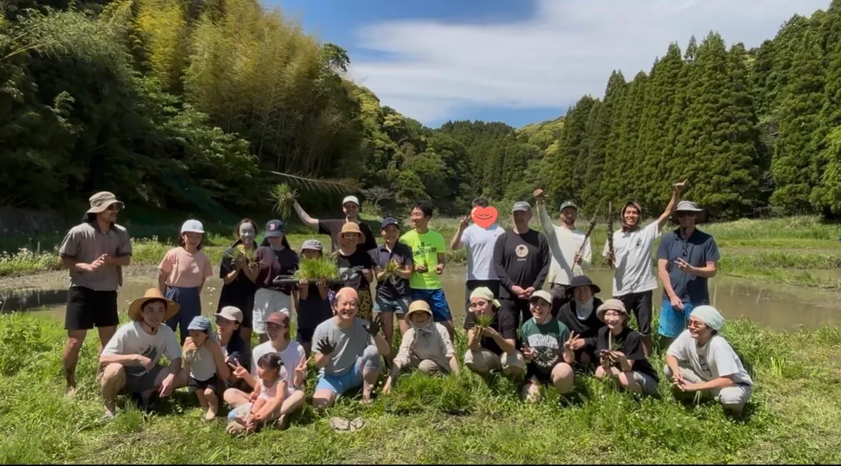 Group picture of people outside surrounded by trees