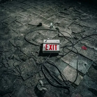 A beat-up exit sign on the floor